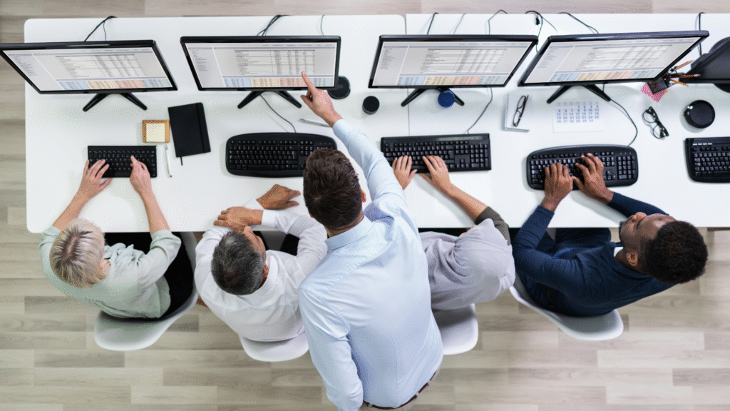 Team collaborating at computers in office setting.