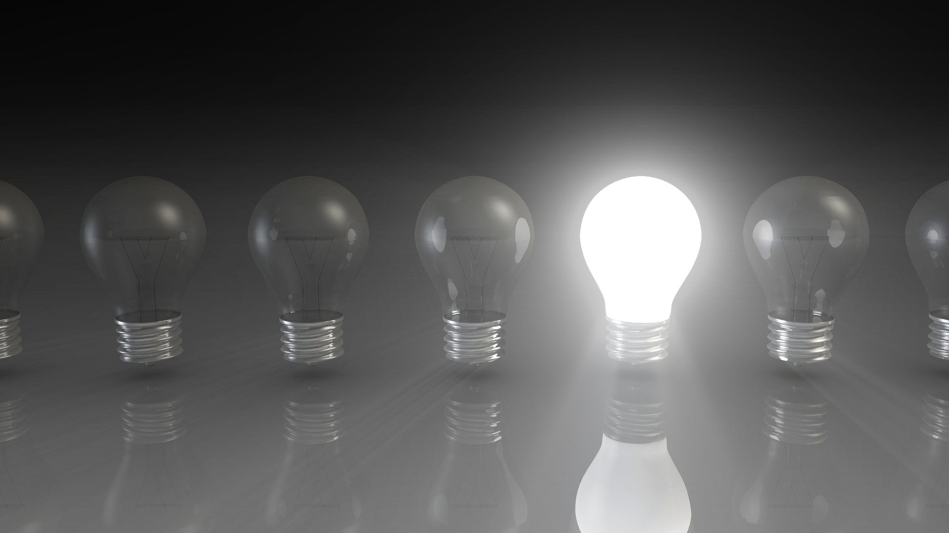 Glowing light bulb among unlit bulbs